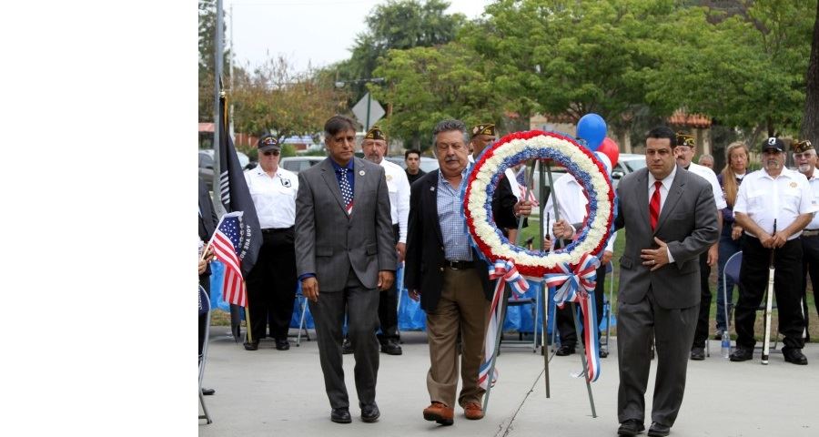 Men standing around colored wreath